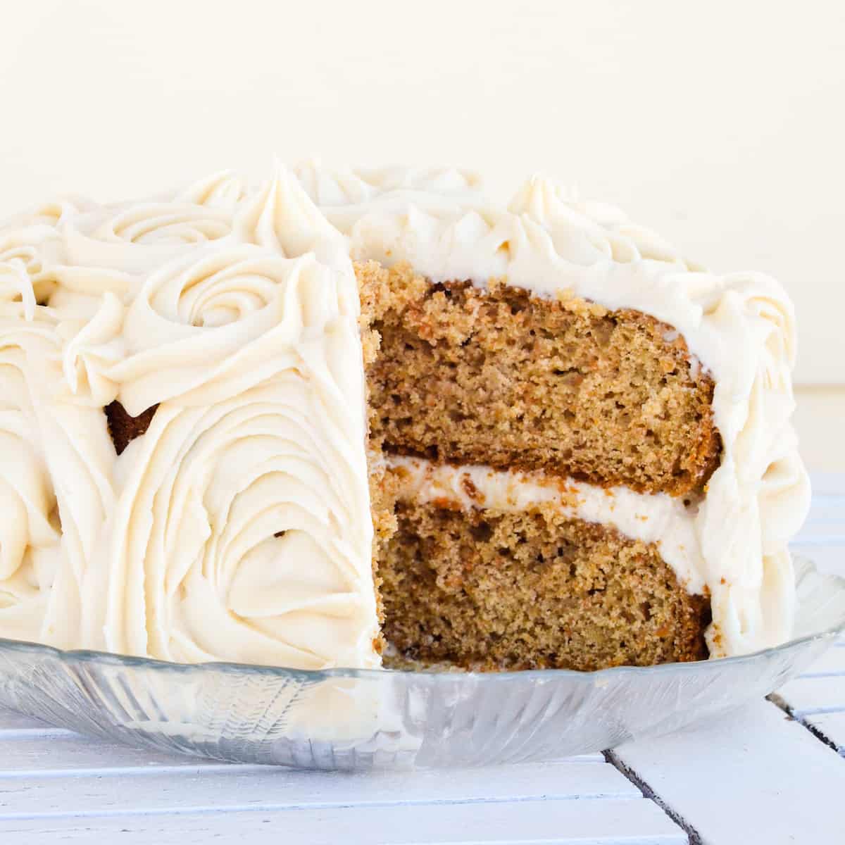 front view of a carrot cake with a slice cut out of it