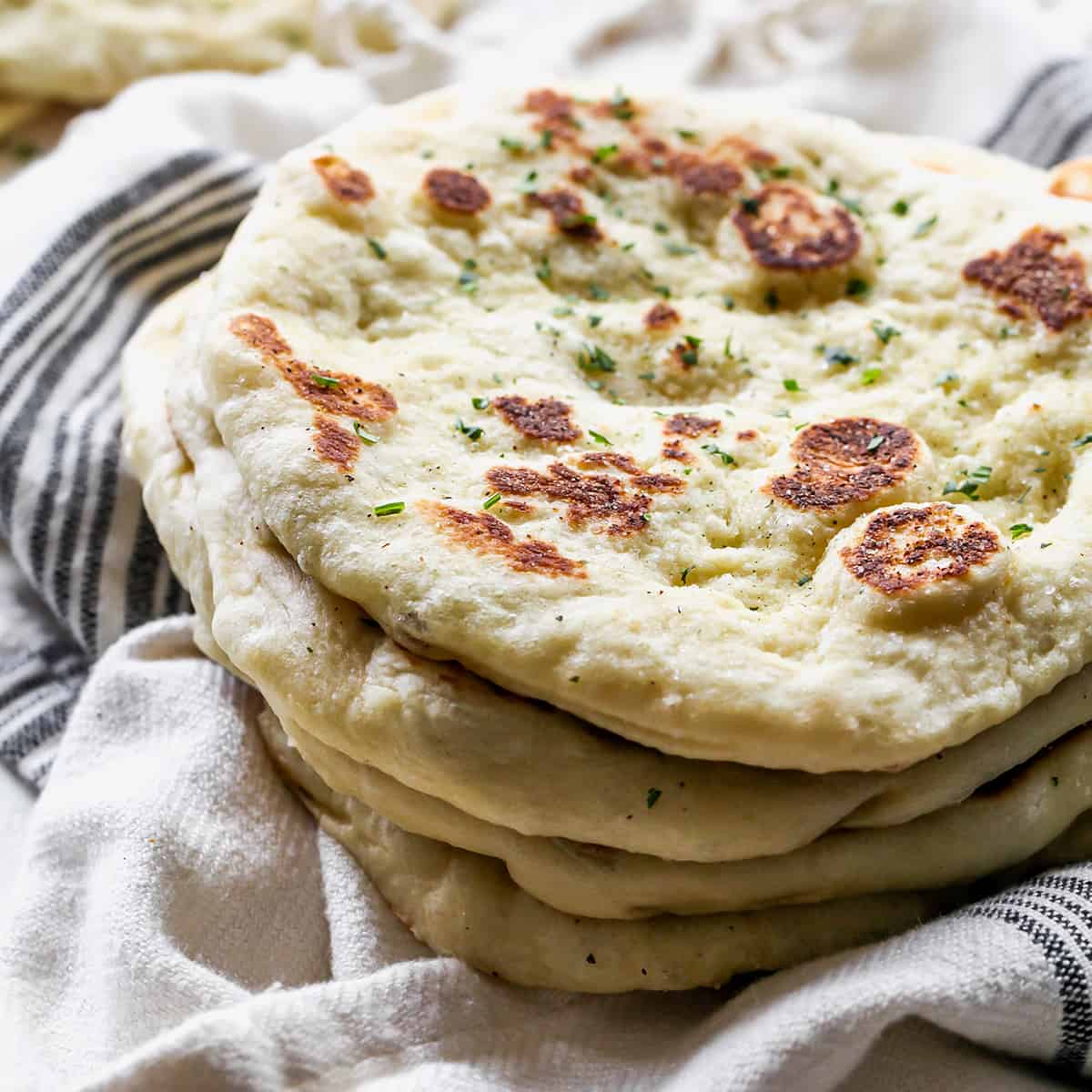 front view of a stack of four pieces of  homemade naan bread