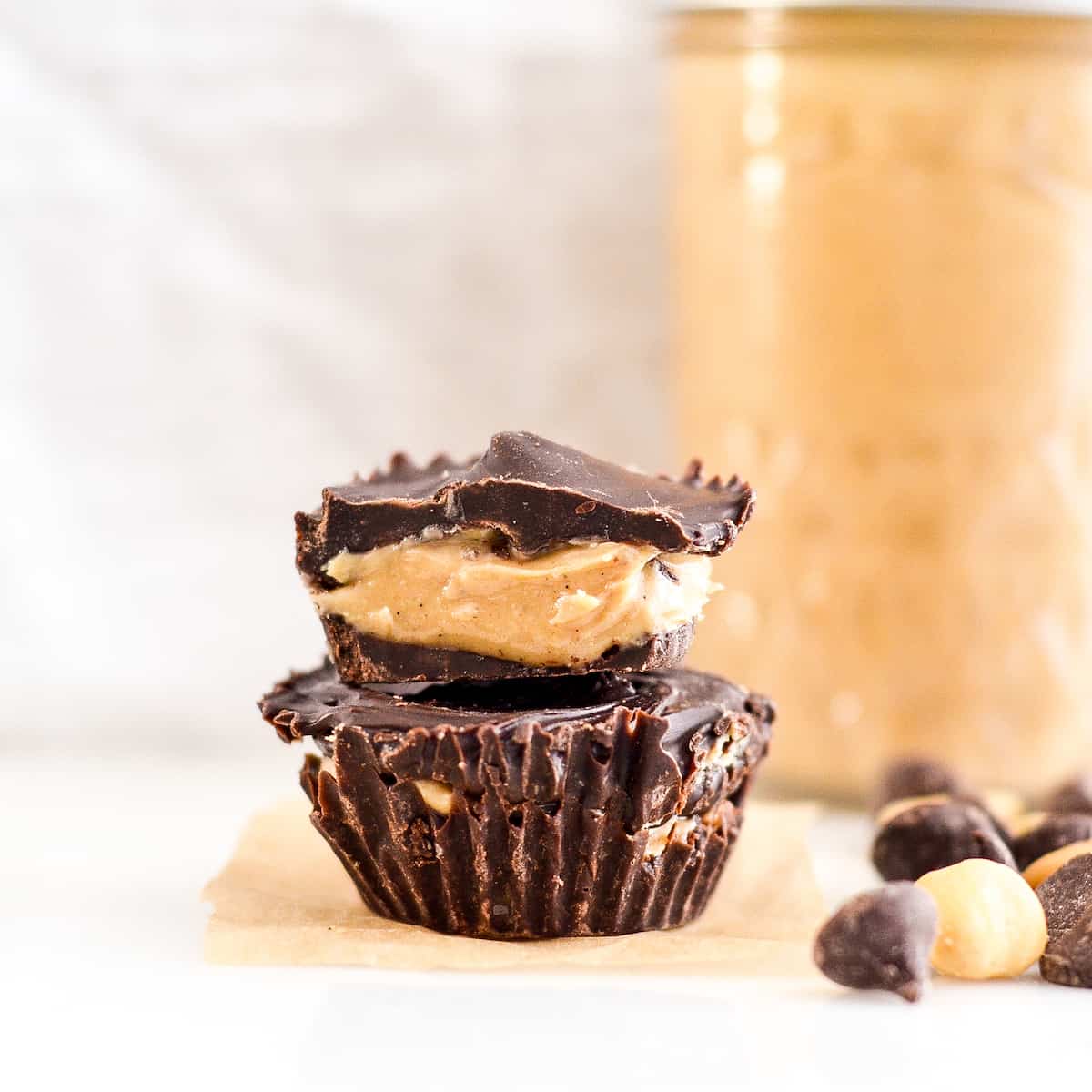 Front view of two Healthy Homemade Peanut Butter Cups stacked on each other. The top is cut in half with the inside showing.