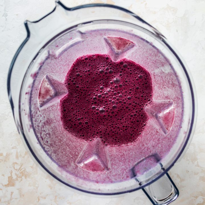 overhead photo showing How to Make a Blueberry Smoothie - ingredient sin the blending container after being blended