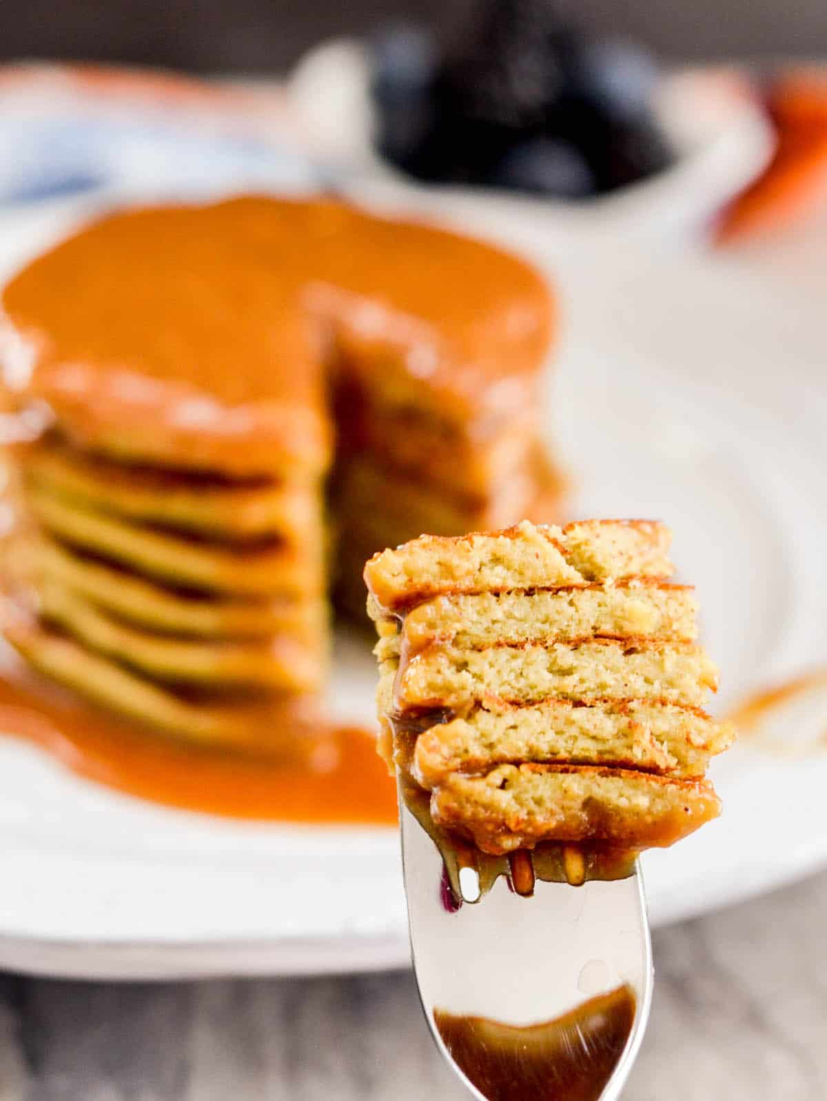 Front view of a bite of Zucchini Banana Pancakes with four pieces of pancake on a fork.