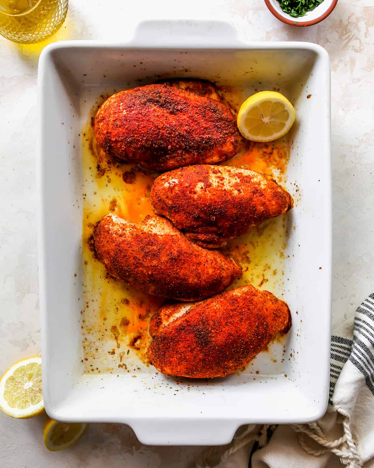 overhead view of four Baked Chicken Breasts in a white baking dish.