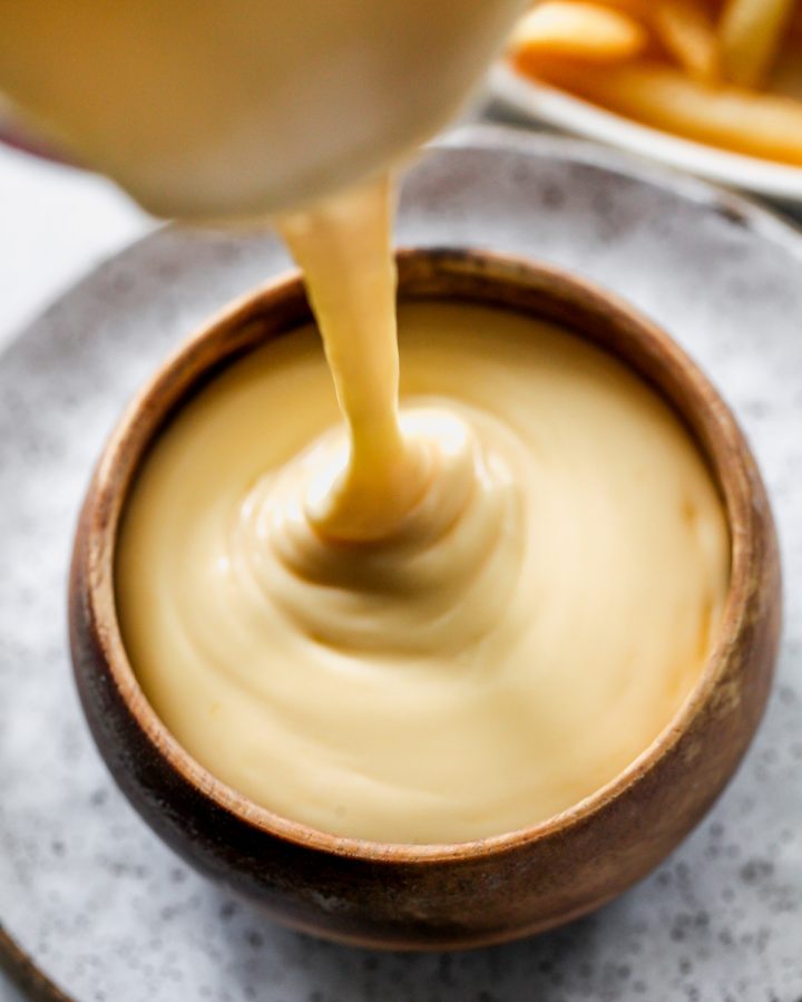 front view of cheese sauce being poured into a bowl
