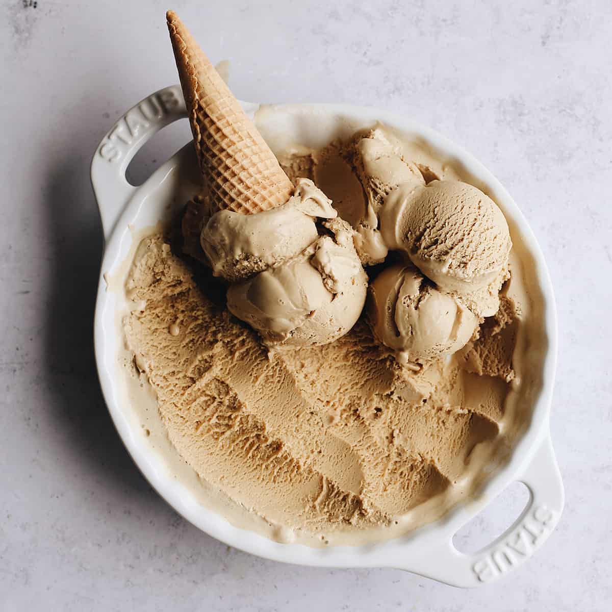 five scoops of Coffee Ice Cream with an ice cream come in a white dish