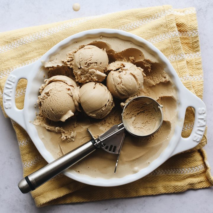 overhead photo of 4 scoops of Coffee Ice Cream in a dish with an ice cream scoop