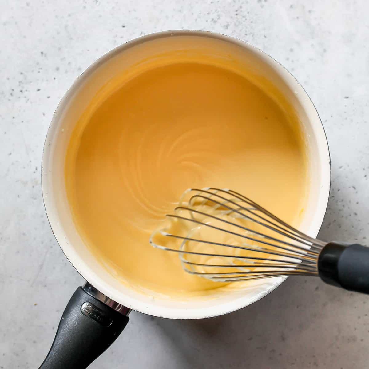 photo showing how to make cheese sauce - whisking the smooth sauce
