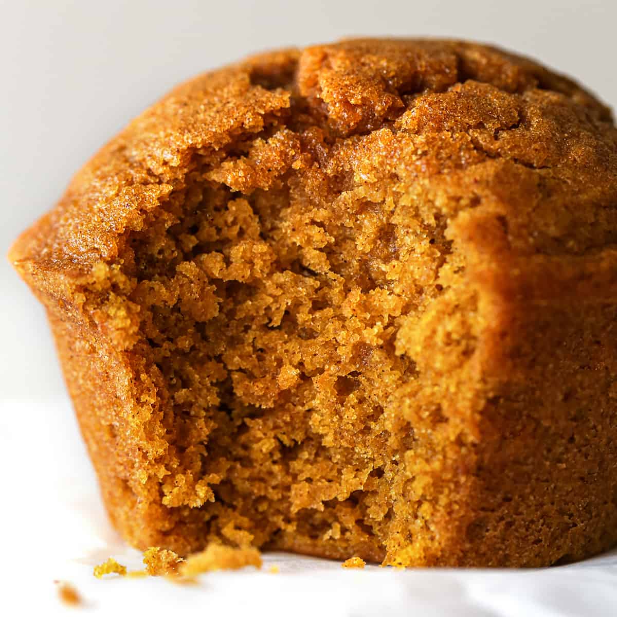up close photo of a pumpkin muffin with a bite taken out of it 