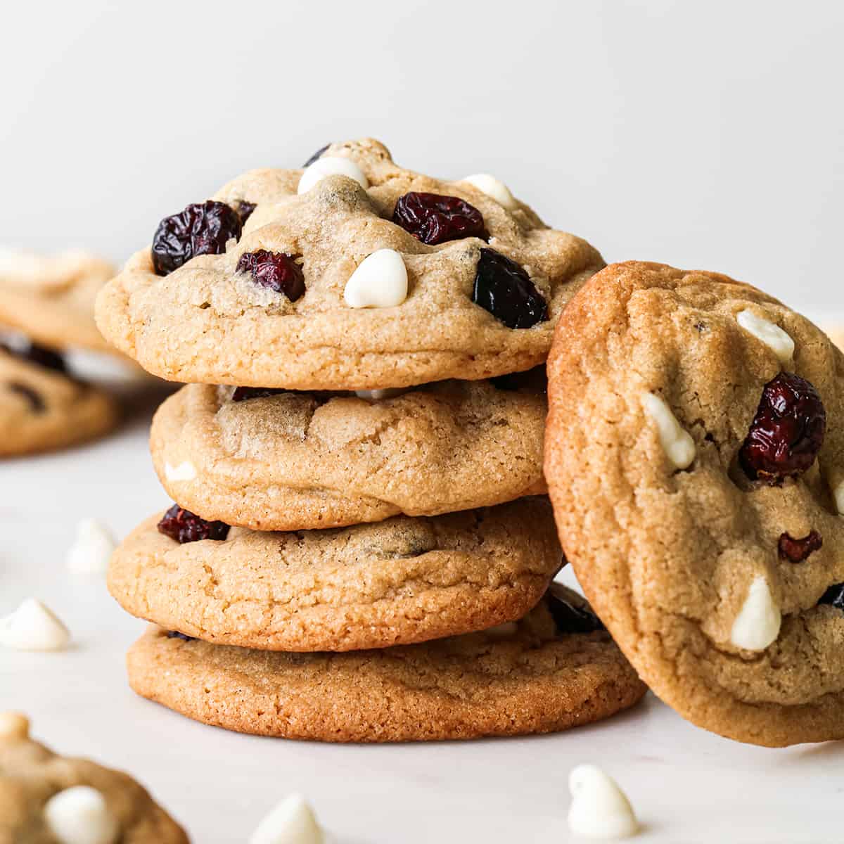 front view of a stack of 4 White Chocolate Cranberry Cookies with one cookie leaning against the stack