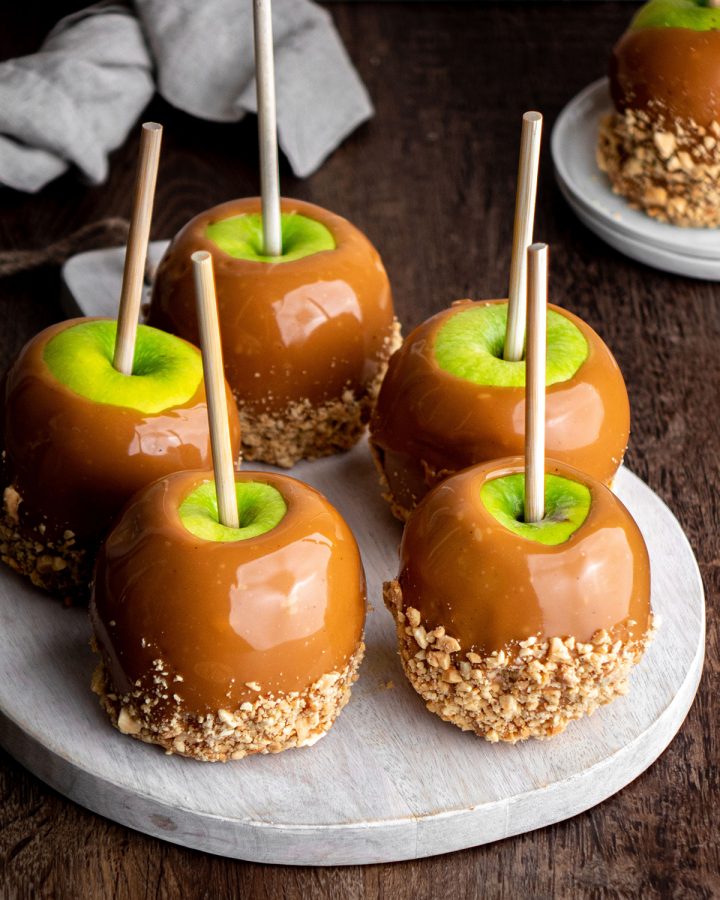 5 Homemade Caramel Apples on a serving board 