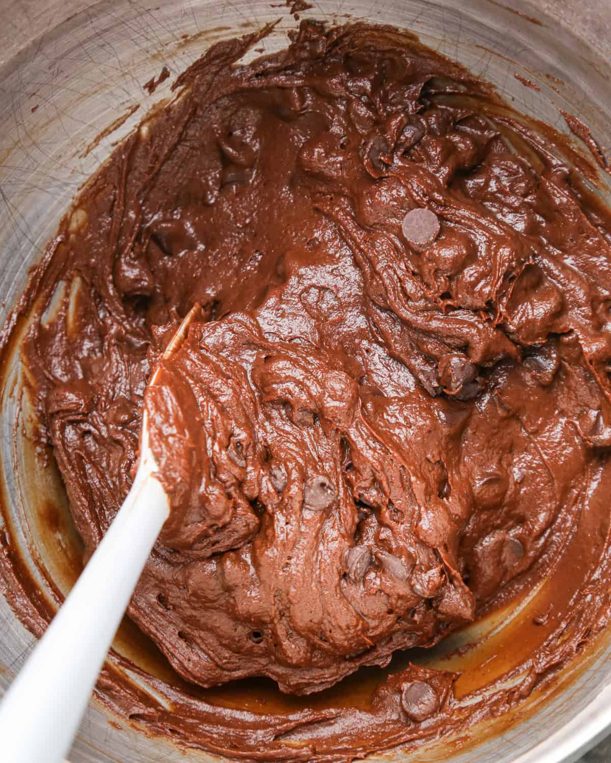 pumpkin brownies batter in a metal mixing bowl with a spatula. 