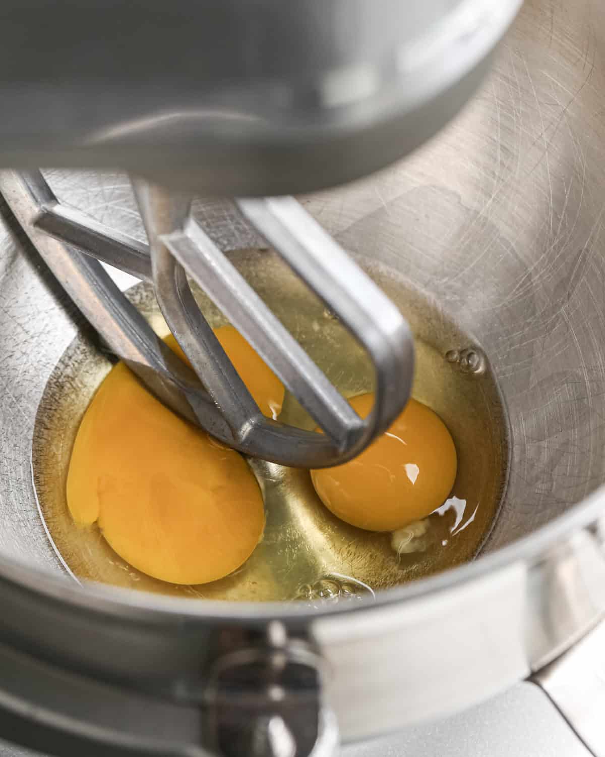 making pumpkin brownies - two eggs in a metal standing mixer bowl with the paddle attachement