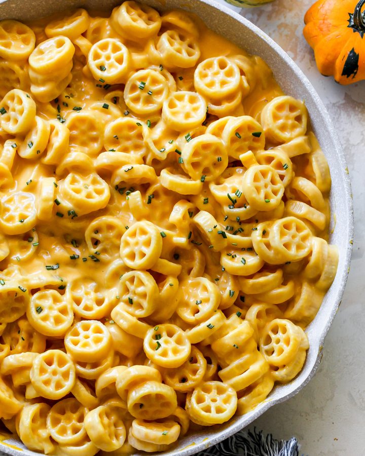 Butternut Squash Mac and Cheese in a pan after it has been cooked garnished with fresh herbs