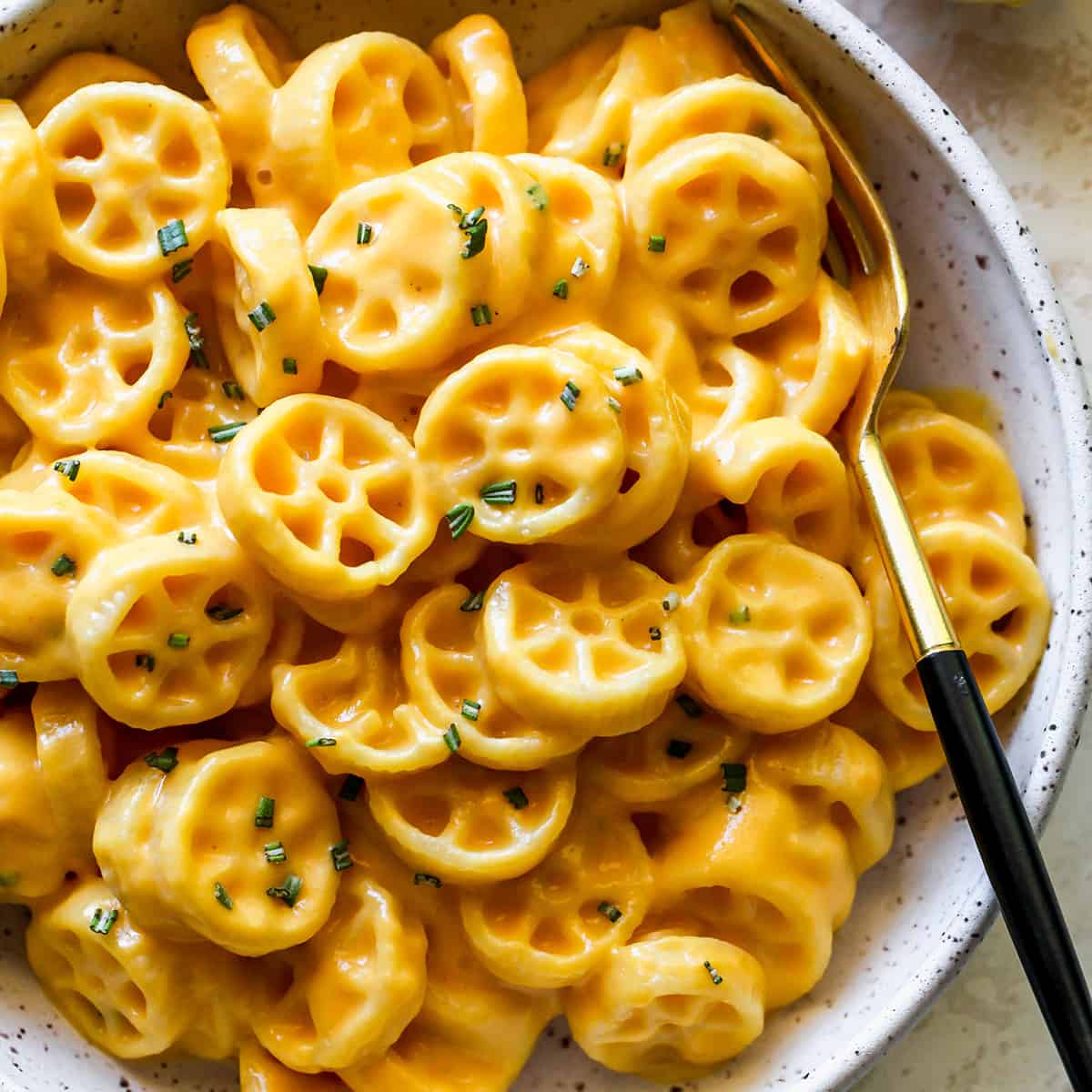 a bowl of Butternut Squash Mac and Cheese garnished with fresh herbs