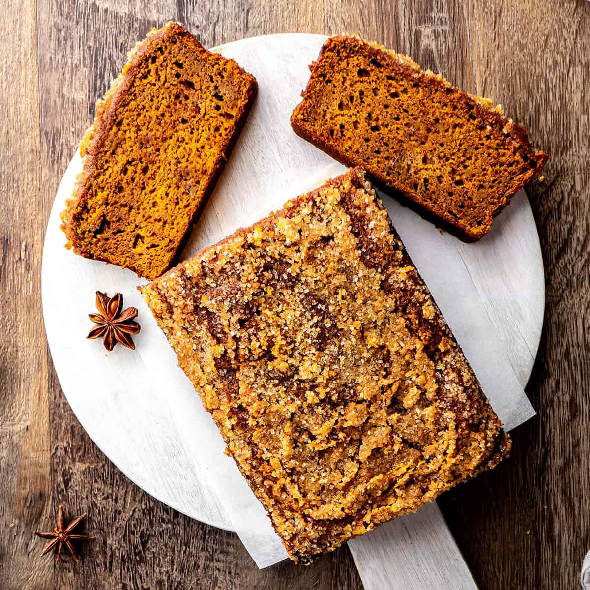 Healthy Pumpkin Bread on a cutting board with 2 slices cut out of it