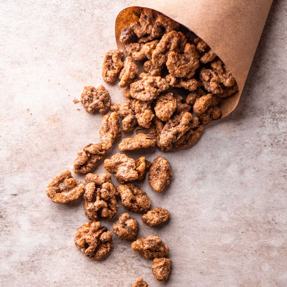 Candied Walnuts spilling out of a brown paper cone