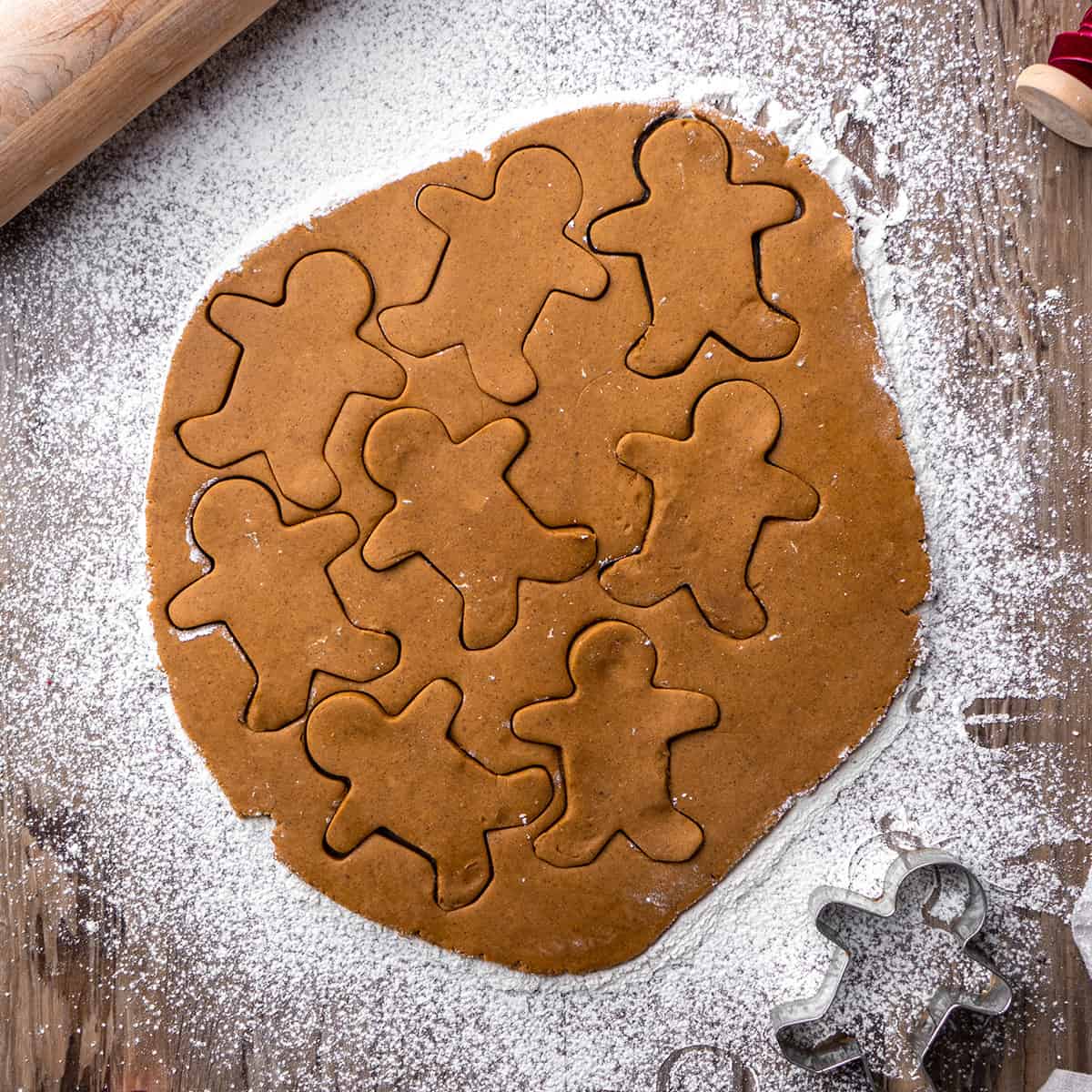 gingerbread cookie dough with gingerbread men cut out of it