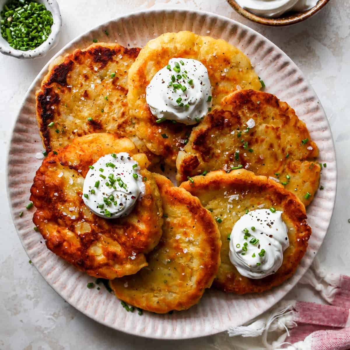 6 Potato Pancakes on a plate with sour cream and chives