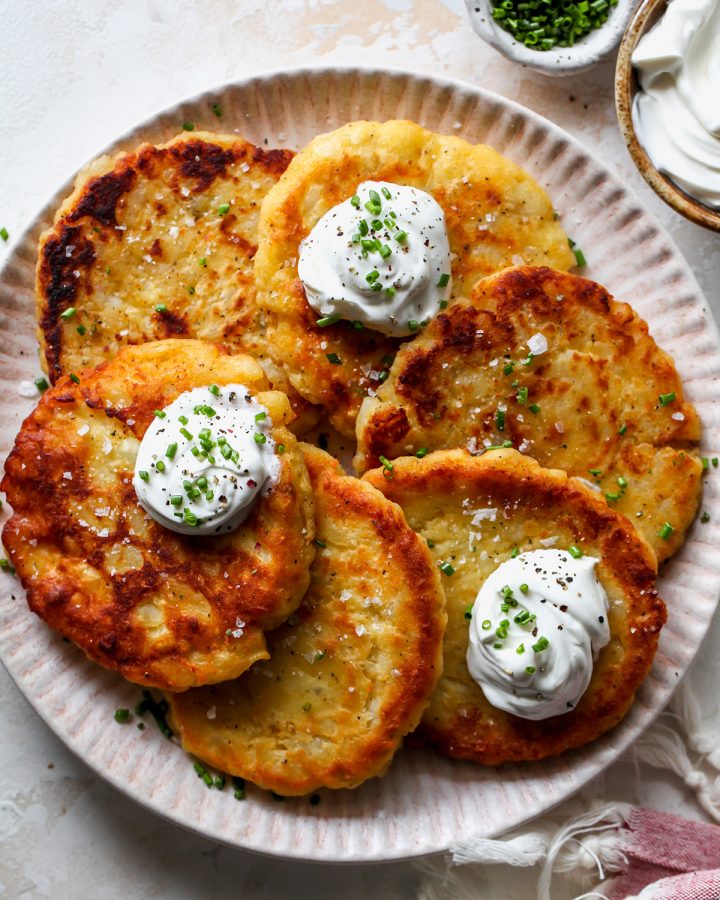 6 Potato Pancakes on a plate garnished with sour cream and chives 