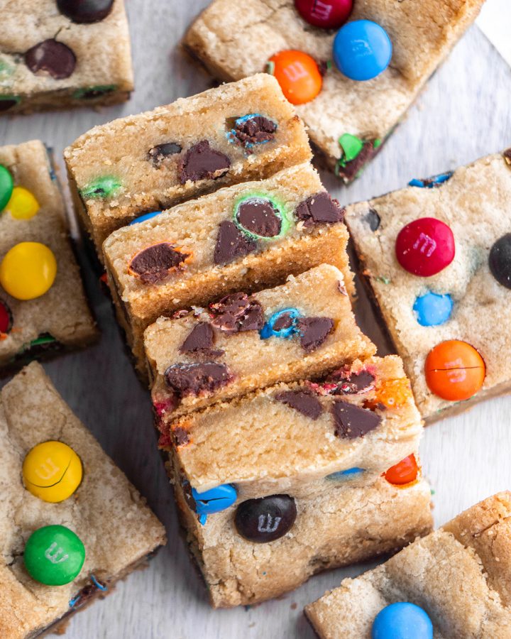 4 M&M Cookie Bars laying on their side so you can see the inside of the bars