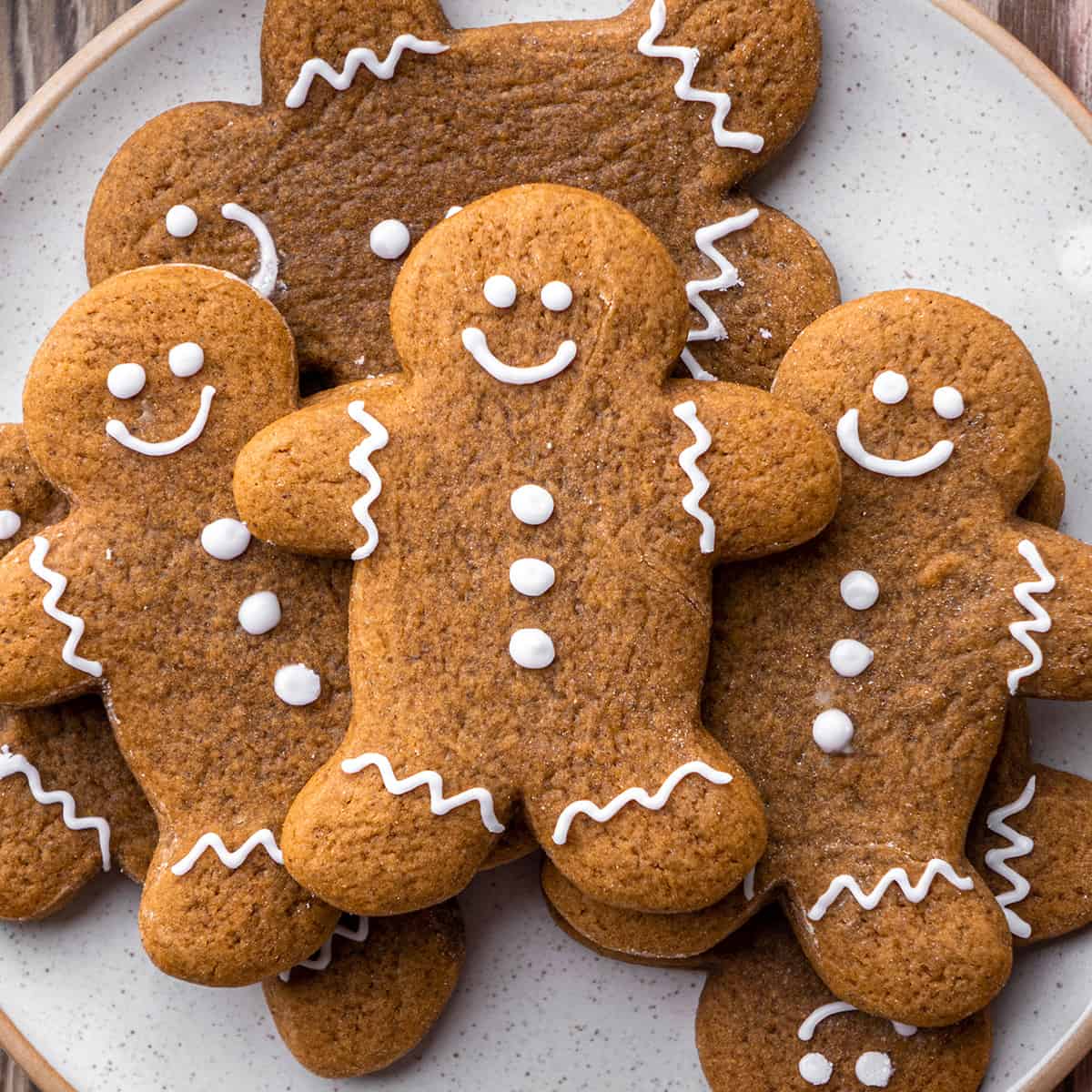 7 Gingerbread Cookies on a plate decorated with glaze 