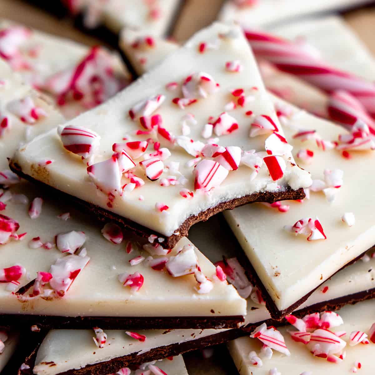 a piece of Peppermint Bark  with a bite taken out of it on top of other pieces of Peppermint Bark 