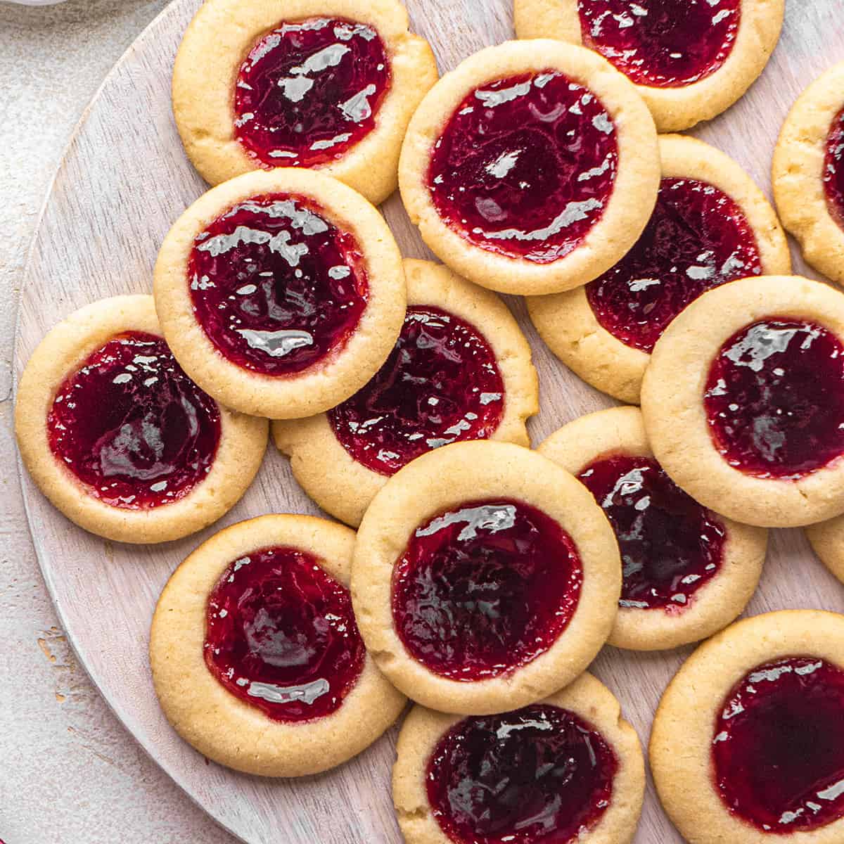 14 Thumbprint Cookies arranged on a wooden serving tray