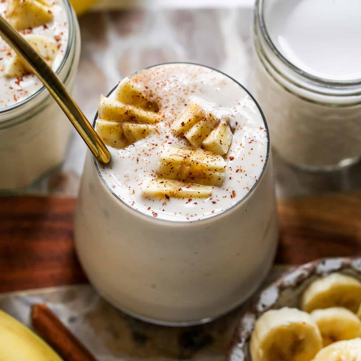 a Banana Smoothie in a glass topped with cinnamon and chopped bananas