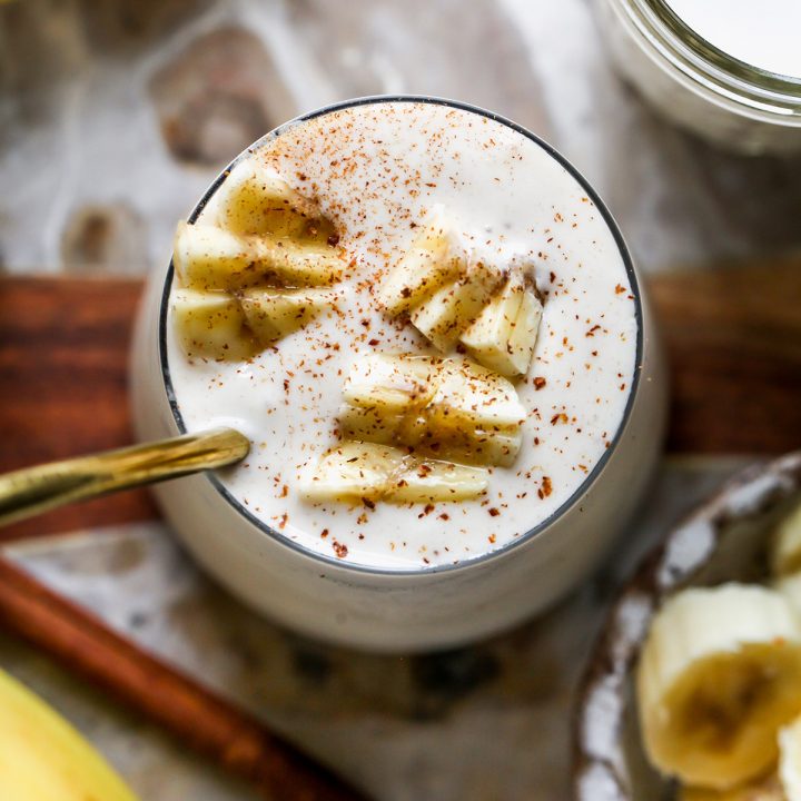 a Banana Smoothie in a glass topped with cinnamon and chopped bananas