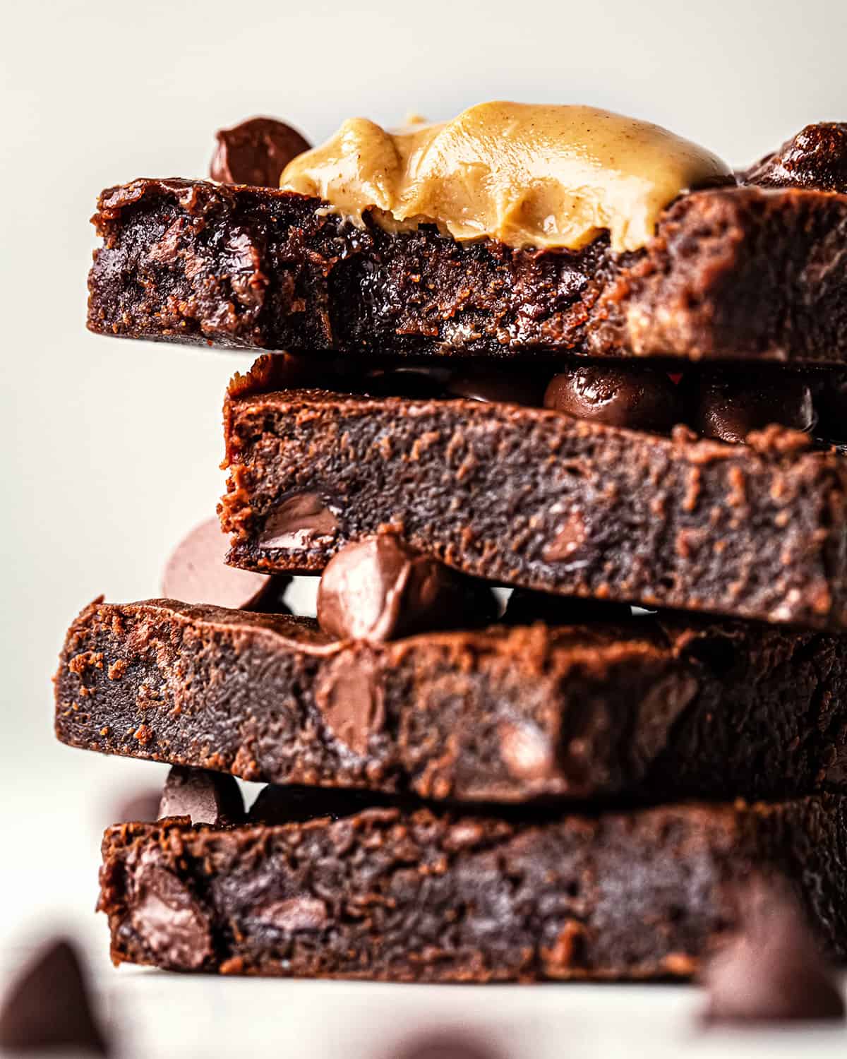a stack fo 4 Healthy Chocolate Peanut Butter Brownies, top one has a bite taken out of it