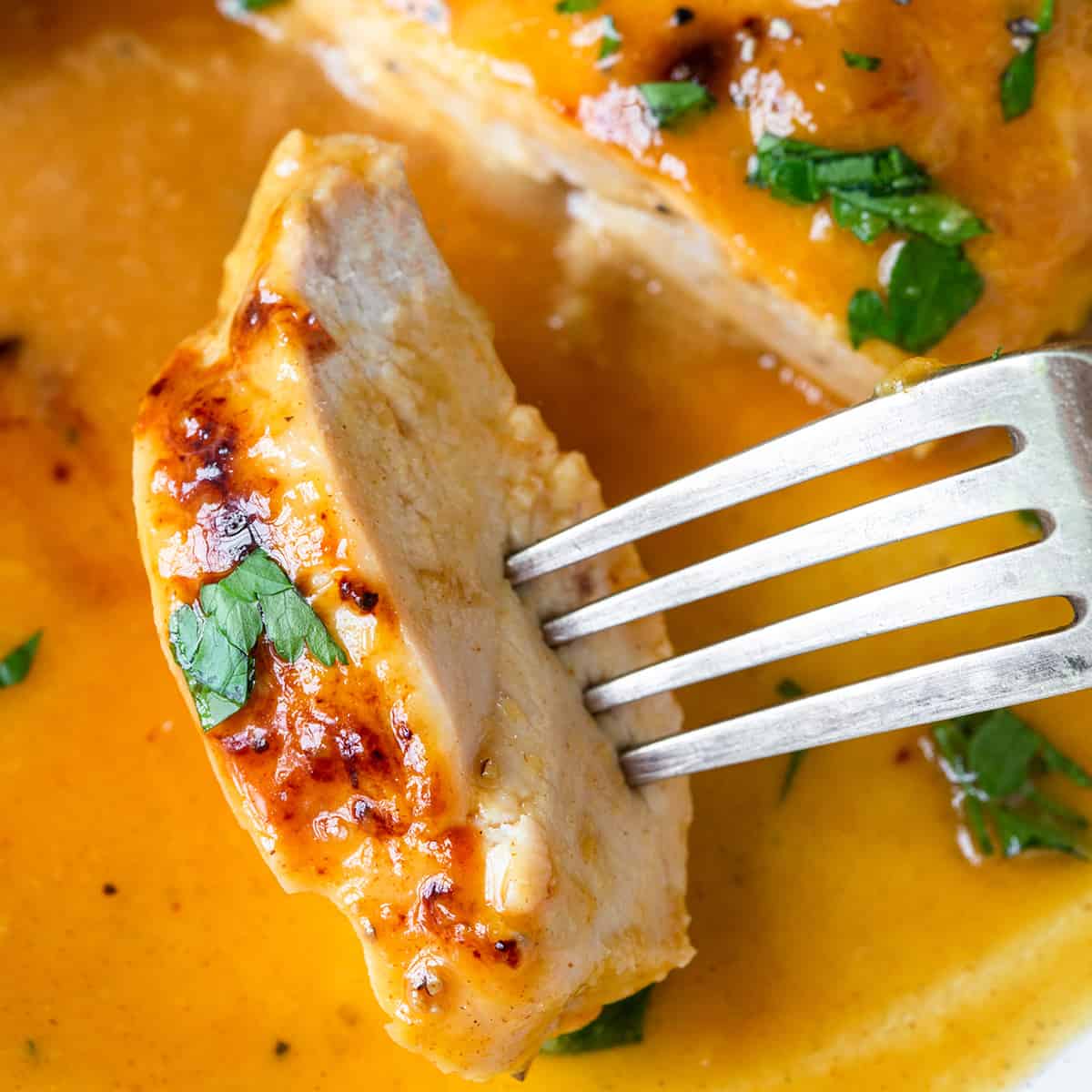 a fork holding a piece of Honey Mustard Chicken breast