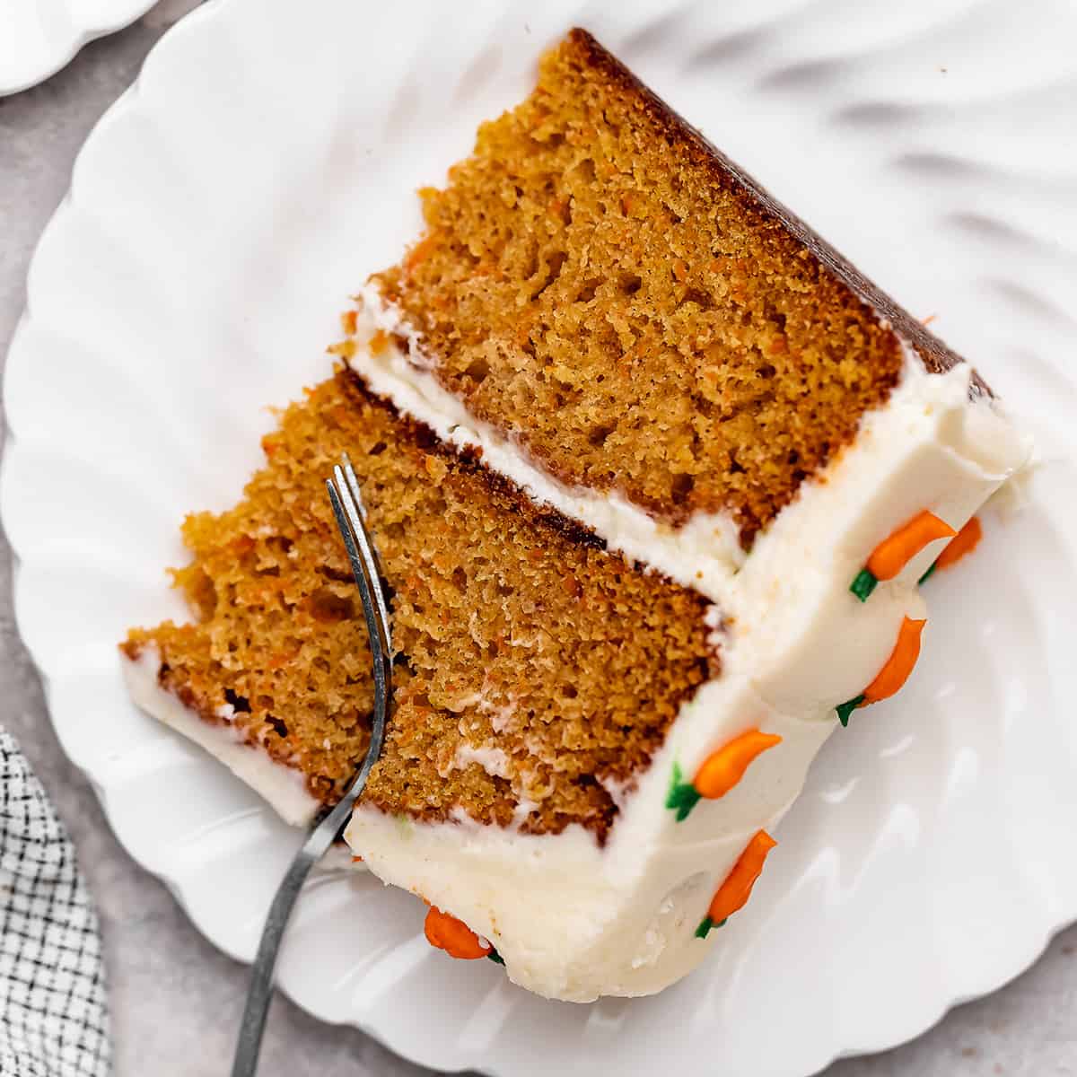 a fork taking a bite out of a slice of Carrot Cake