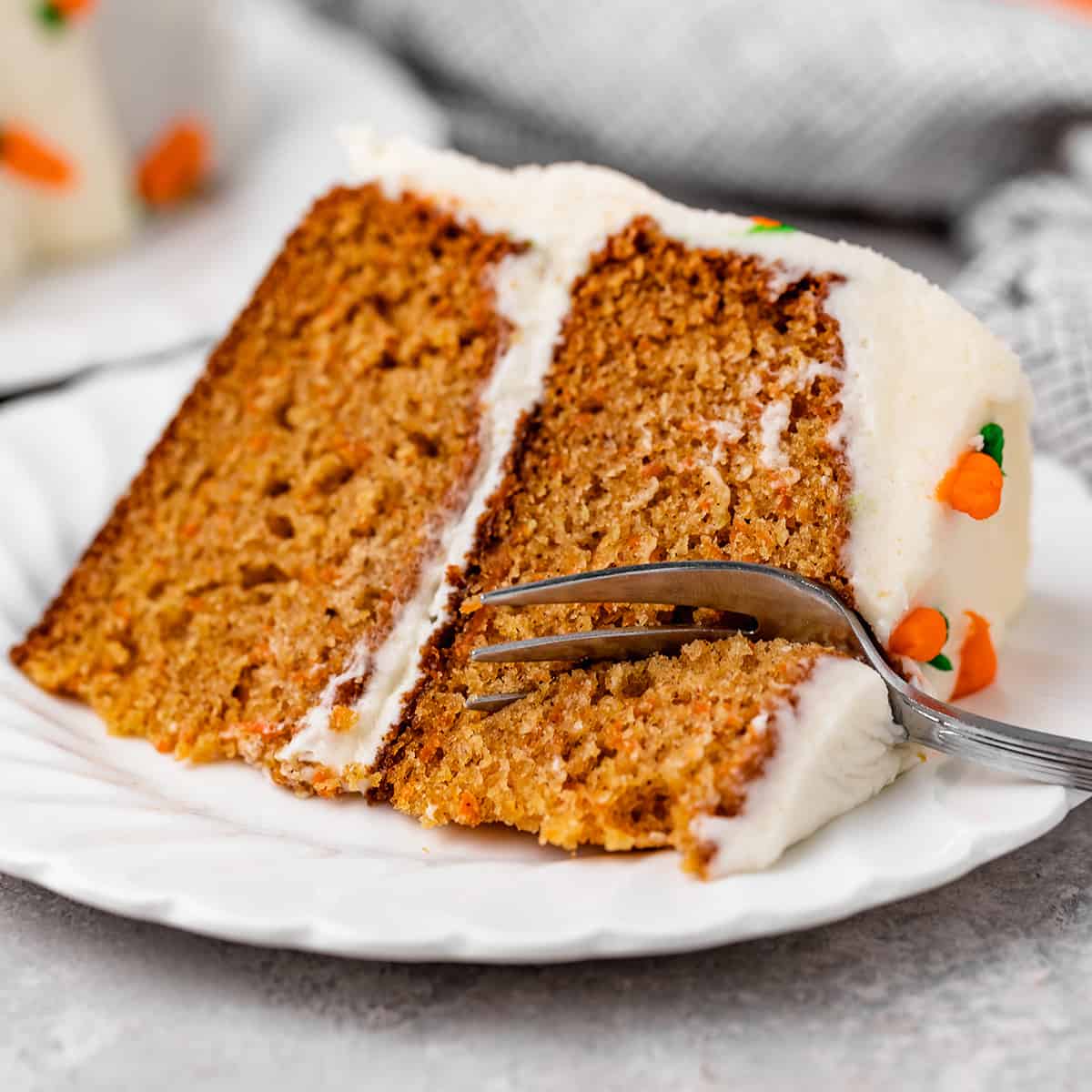 a fork taking a bite out of a slice of carrot cake