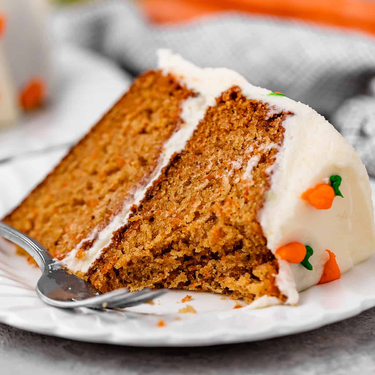 a slice of carrot cake with a bite taken out of it 