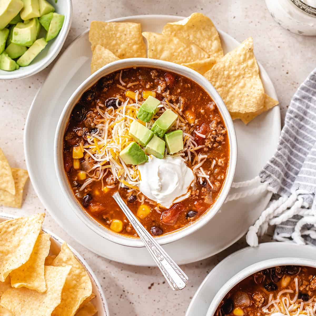a bowl of Taco Soup topped with sour cream, avocado and cheese 
