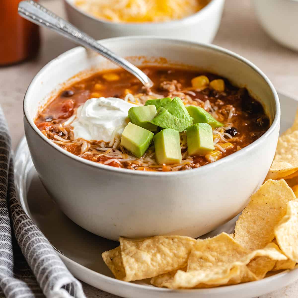 a bowl of slow cooker Taco Soup topped with sour cream and avocado and cheese