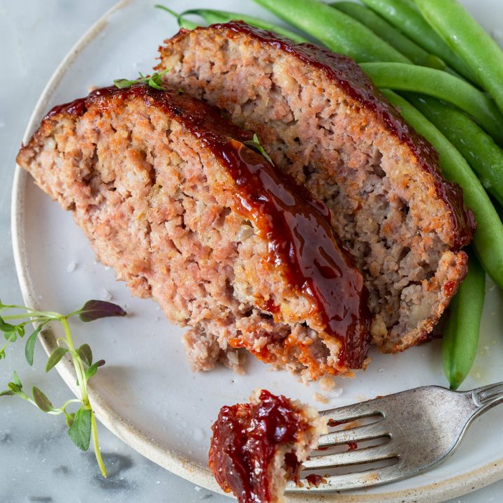 two slices of Turkey Meatloaf, a fork taking a bite out of one
