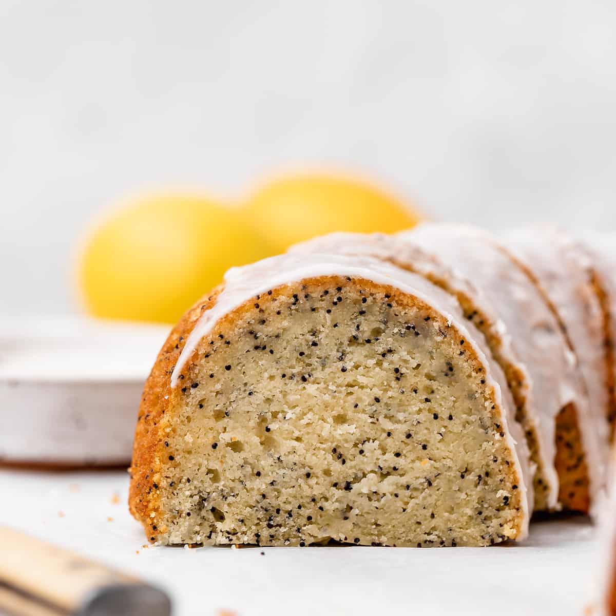 front view of a Lemon Poppy Seed Cake with a piece cut out of it so the texture is visible