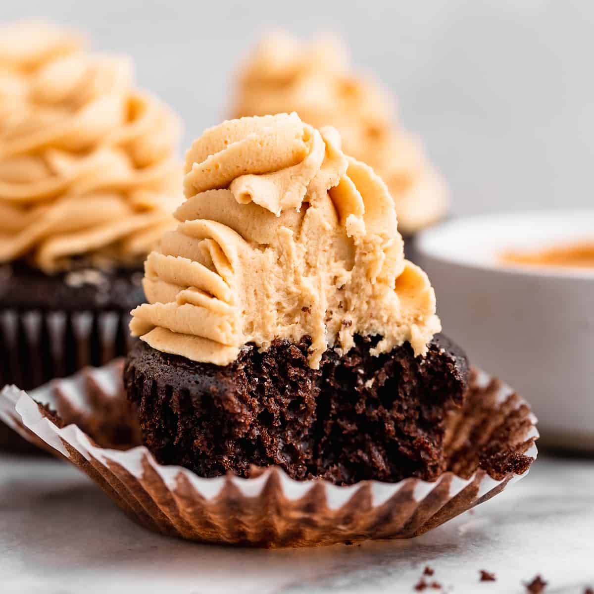 Peanut Butter Frosting on top of a chocolate cupcake with a bite taken out of it