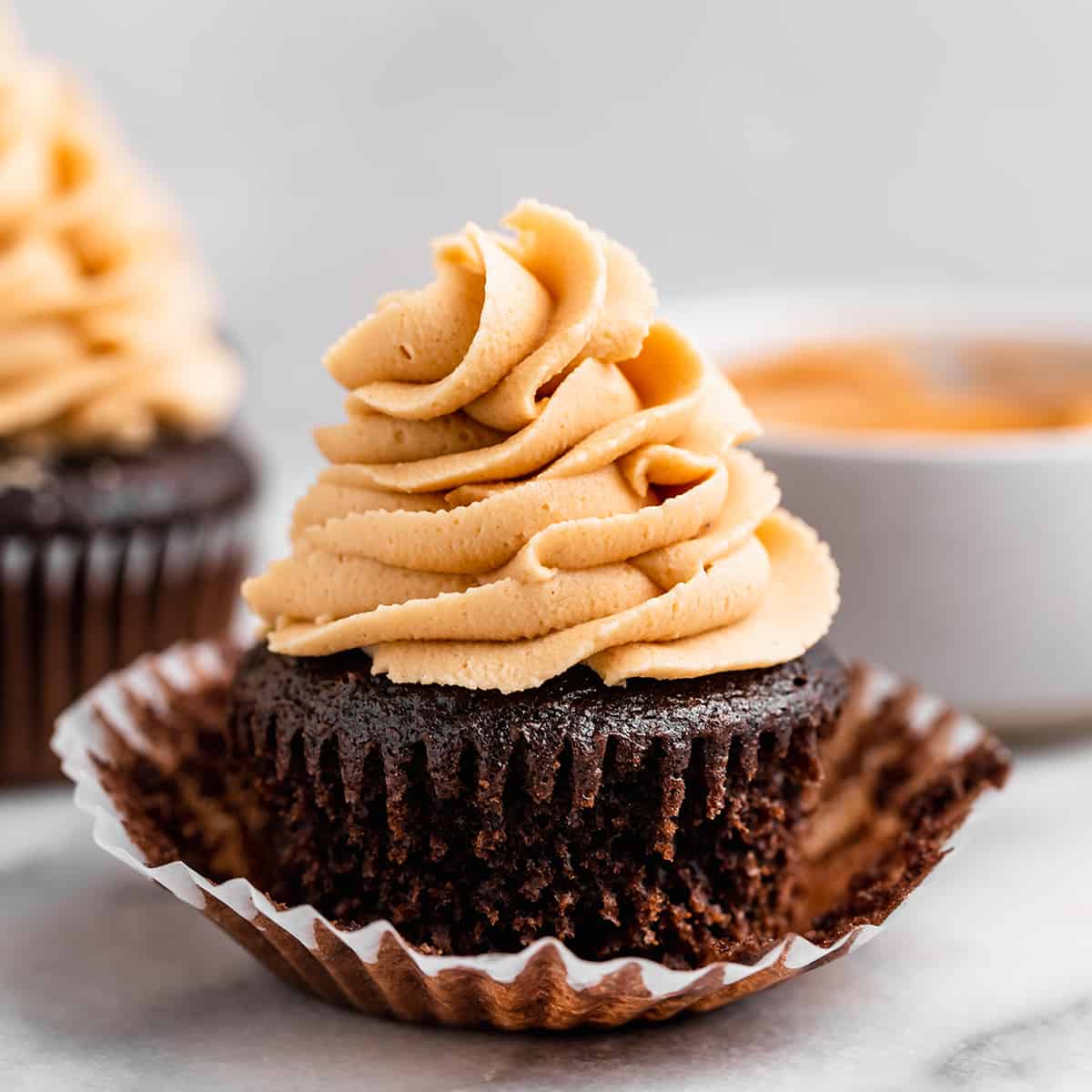 Peanut Butter Frosting piped on top of a chocolate cupcake
