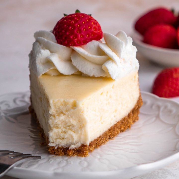 a slice of cheesecake on a plate with a bite taken out of it