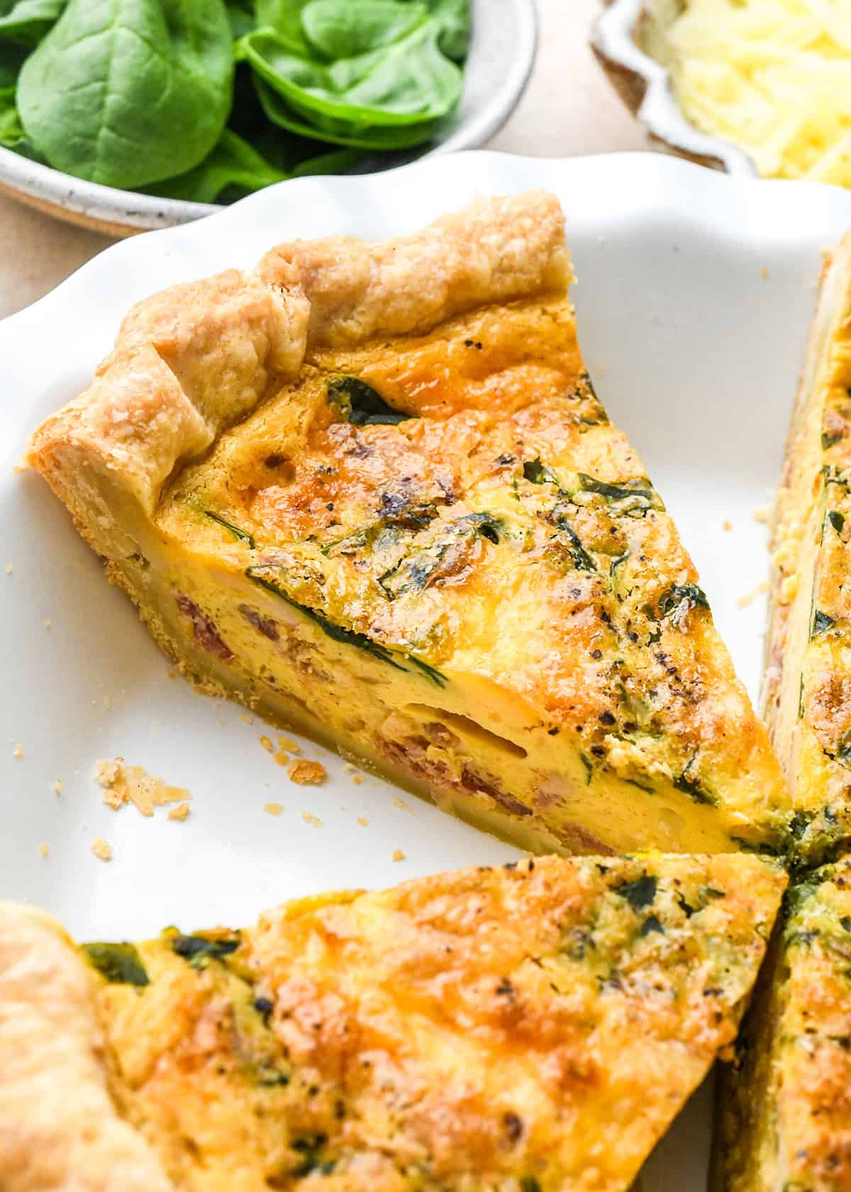a slice of the Best Easy Quiche Recipe in a pie dish