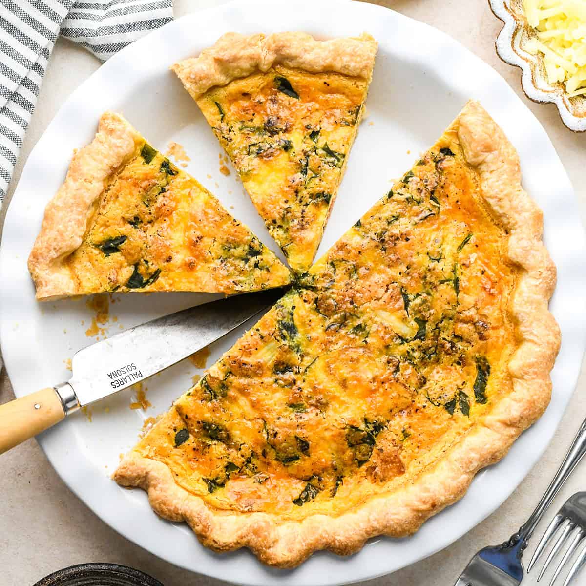 quiche in a pie dish with two slices cut 