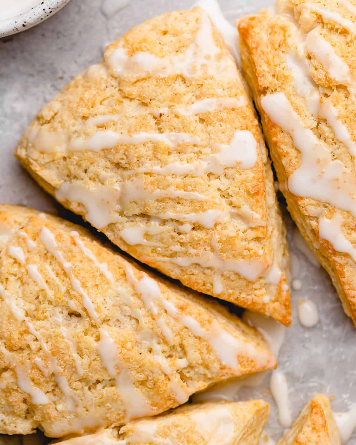 three scones with glaze drizzled on the top