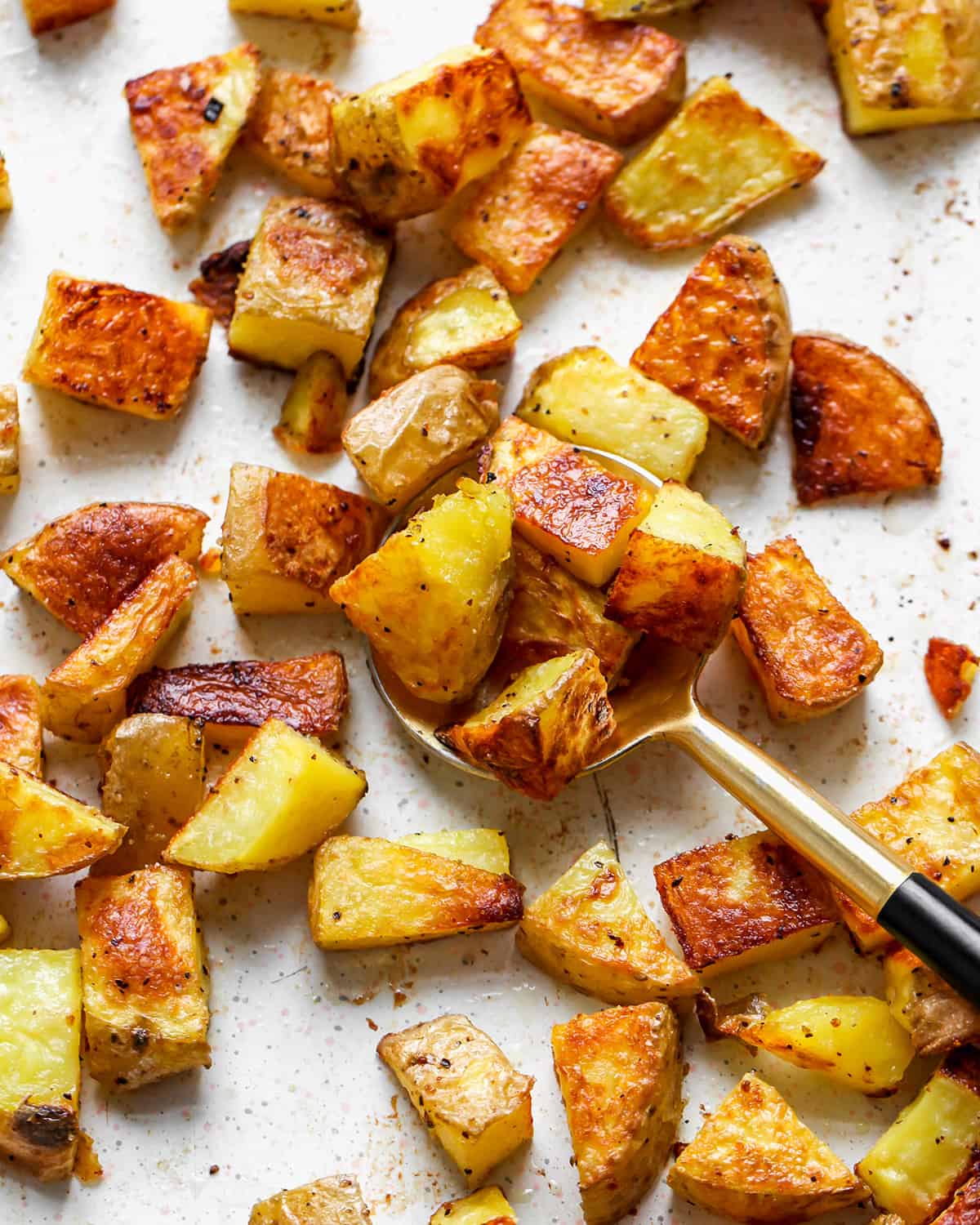 Oven Roasted Potatoes on a baking sheet with a spoon