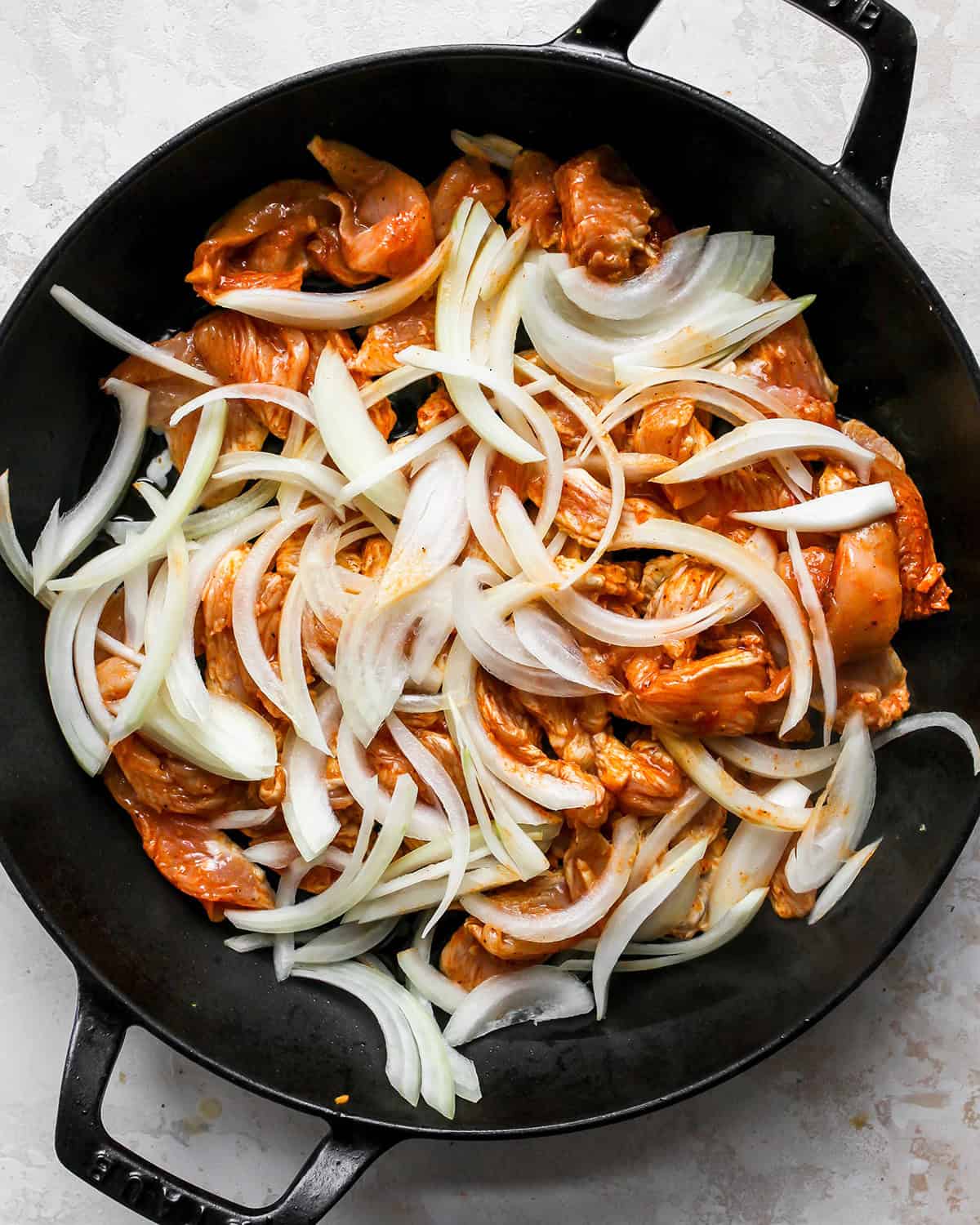 making chicken fajitas - marinated chicken, onions and garlic in a back cast iron skillet before cooking