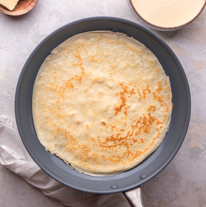 a photo showing How to Make Crepes - cooked crepe in a pan