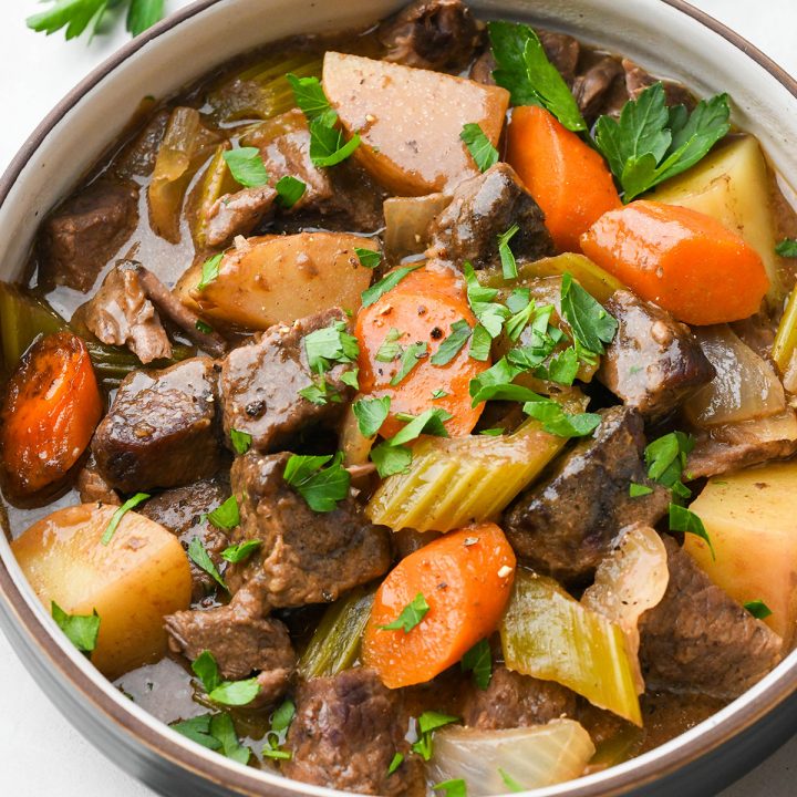 a bowl of Slow Cooker Beef Stew garnished with fresh parsley.