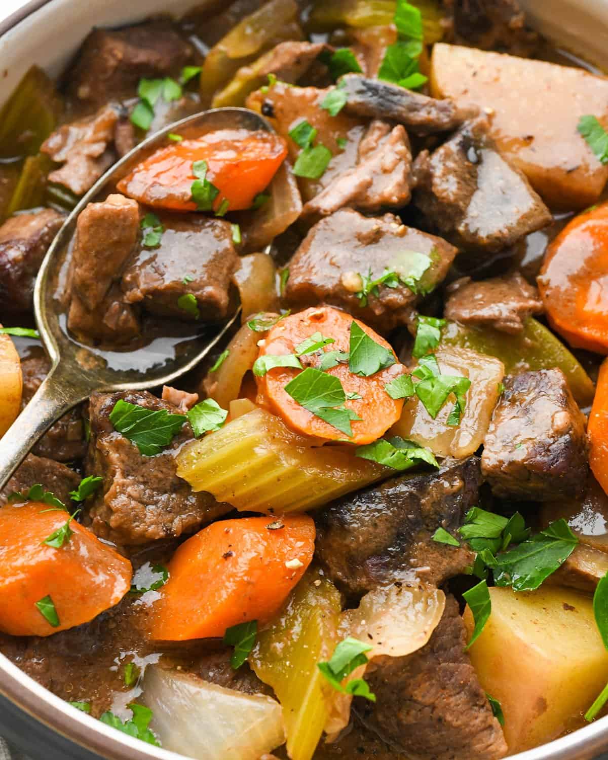 a spoon taking a bite of Slow Cooker Beef Stew in a bowl