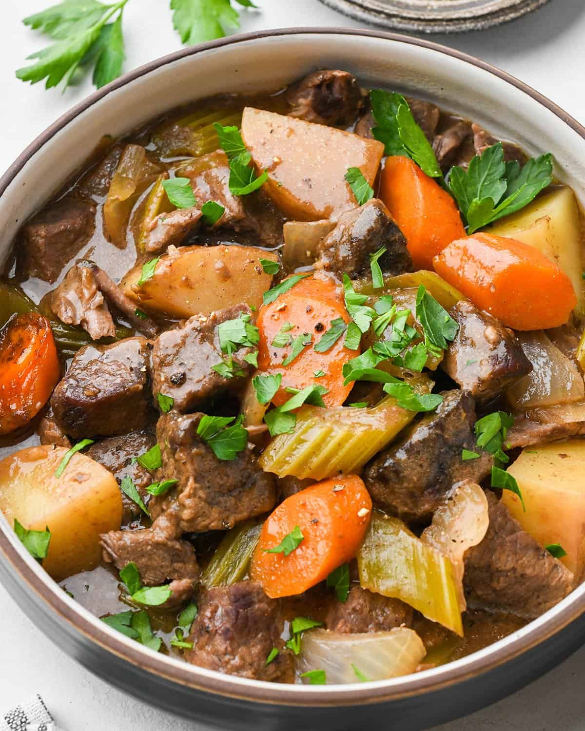 a bowl of Slow Cooker Beef Stew garnished with fresh parsley.