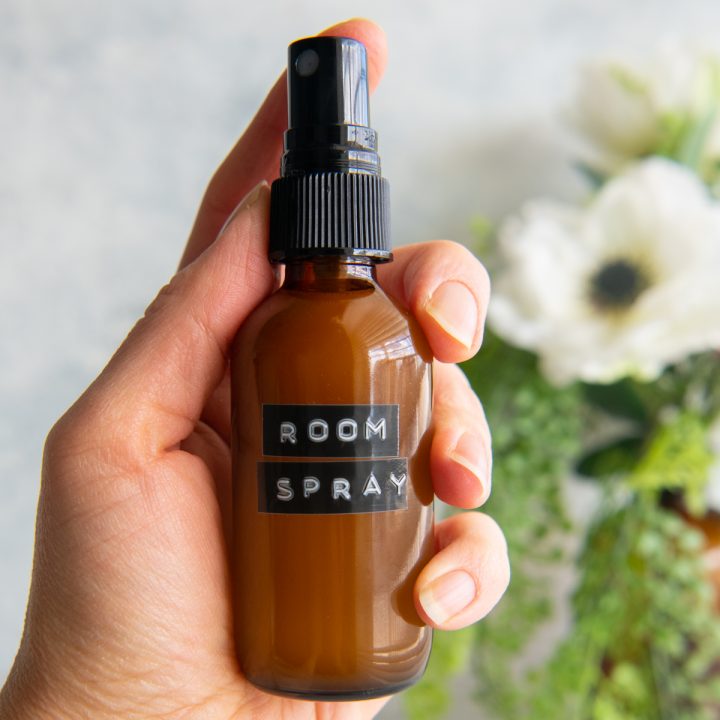 a hand holding a bottle of DIY Essential Oil Room Spray
